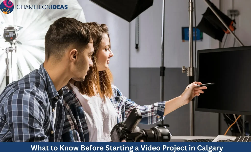 Two photographers reviewing photos on computer monitor in professional studio with lighting equipment and camera gear