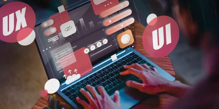 Person typing on laptop with floating UI elements and design icons showing website design process
