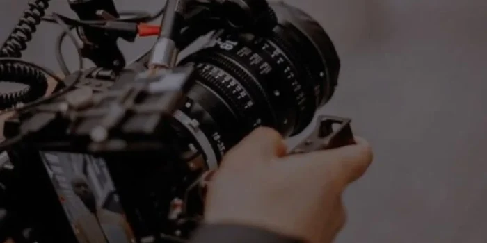 Professional camera with monitor rig held by operator hands