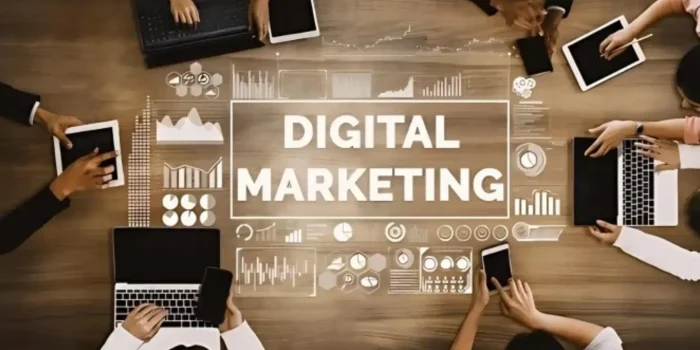 Overhead view of digital marketing team meeting with laptops, tablets and analytics graphics on wooden conference table