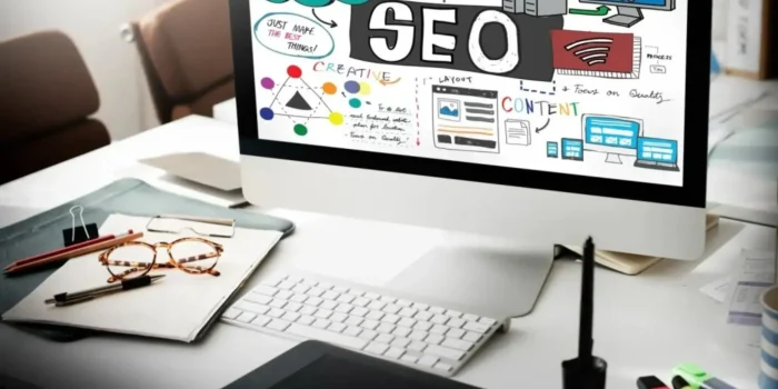 Desktop computer displaying SEO infographic in office setup